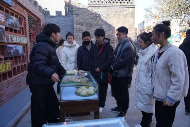 在西磑村非遗年货节上，年轻游客和摊主聊起来。河津市融媒体供图