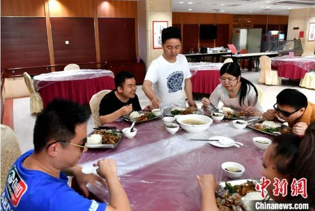 朱伟贤为“看到”组合的成员盛汤。中新社记者 吕明 摄