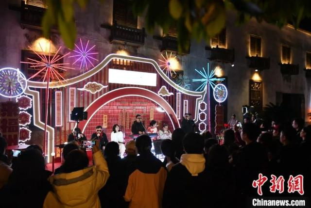 成员在三坊七巷演出引路人围观。中新社记者 吕明 摄