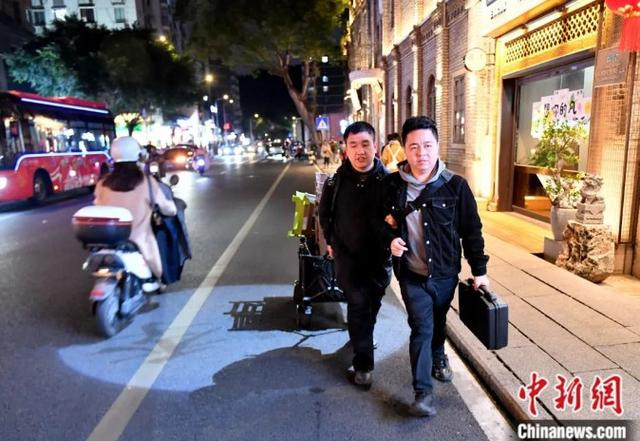 朱伟贤带着黄延平走向演出地。中新社记者 吕明 摄