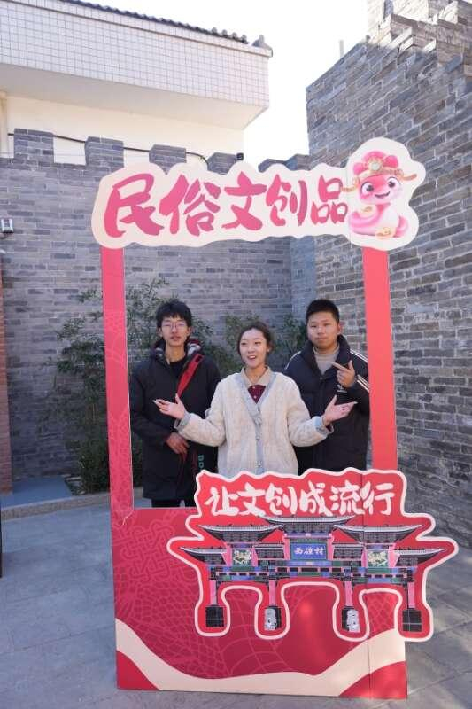 在西磑村非遗年货节上，年轻游客正在民俗文化打卡点打卡。 河津市融媒体供图