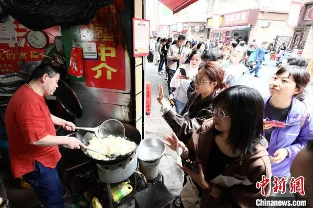 图为游客正在购买南昌小吃白糖糕。刘思伟 摄