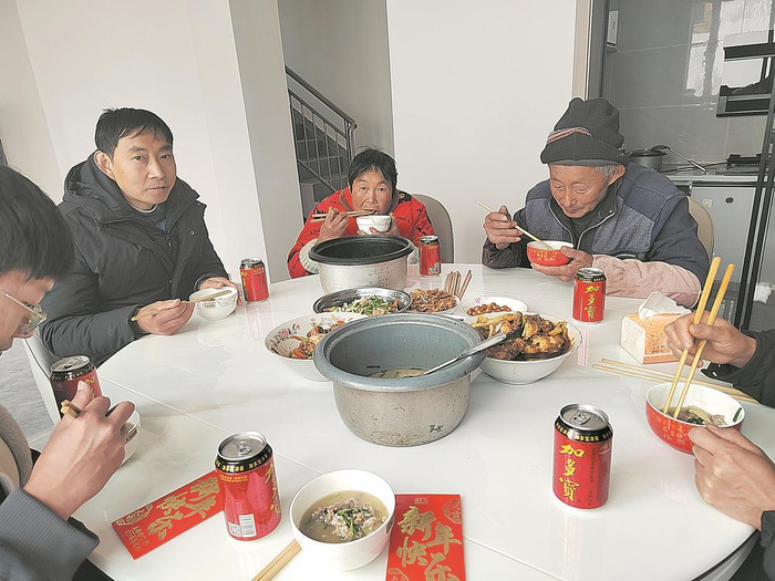     村民搬进新家，正吃着团圆饭。