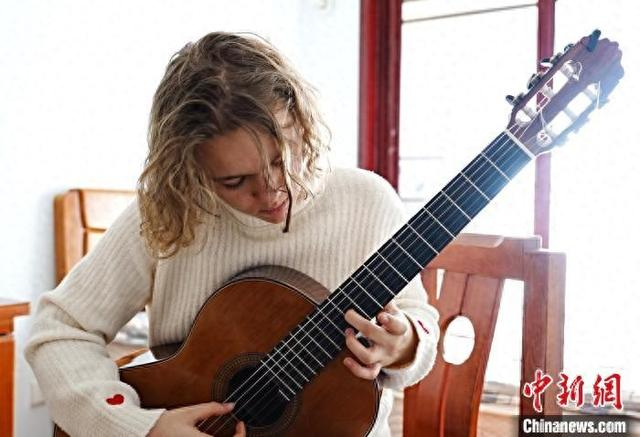 图为罗马尼亚姑娘谢娜正进行吉他演奏。王峰 摄