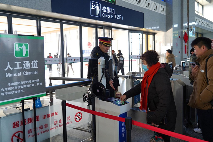 淮南南站客运人员组织旅客有序检票进站。王神莹  图