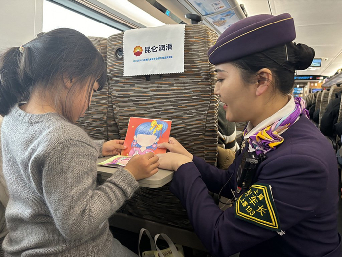 上海客运段列车长为儿童旅客送上涂色卡。 汤雯 图