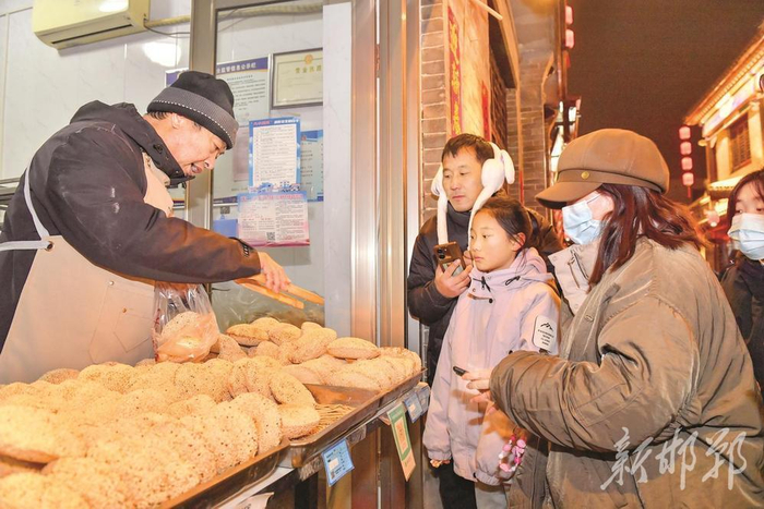1月31日，游客在购买用非遗技艺制作的芝麻酥烧饼。