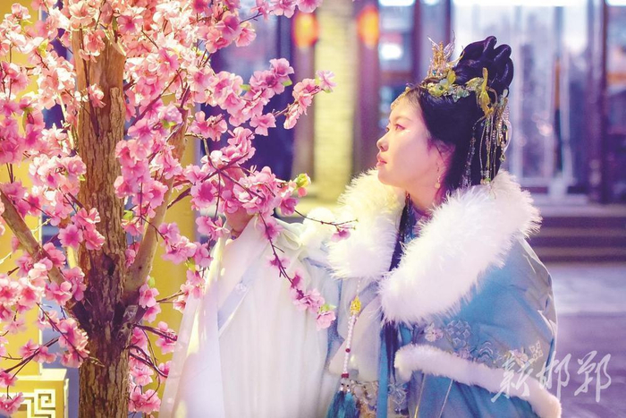 1月31日，身着古装的姑娘在广府古城驻足赏花。