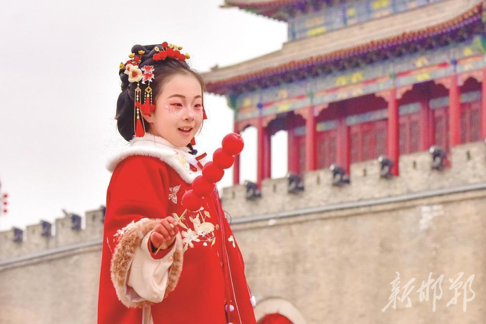 1月31日，广府古城南门，小朋友向游客展示冰糖葫芦。