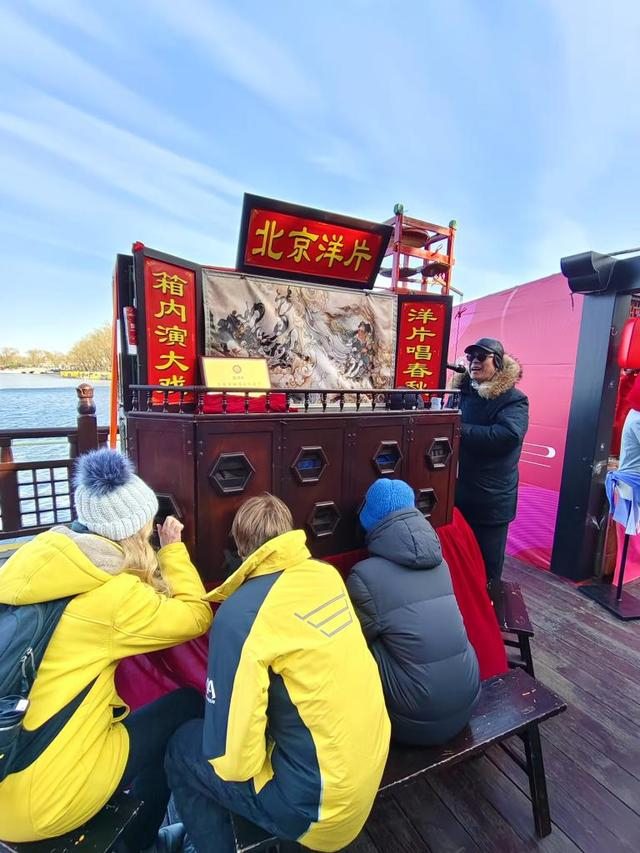 乌尔丽克与埃米尔在什刹海看北京洋片表演。新华社记者于佳欣摄