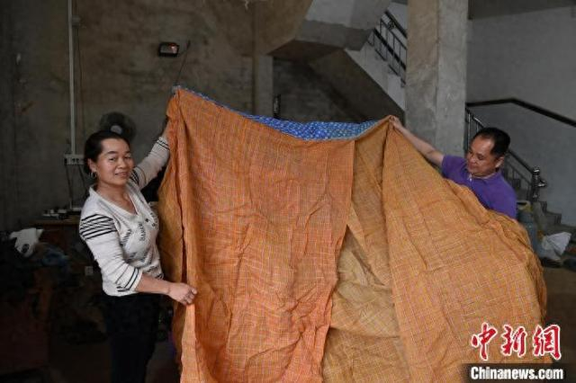 1月23日，黄小英和丈夫一起向记者展示用壮锦制作的嫁妆。中新社记者 蒋雪林 摄