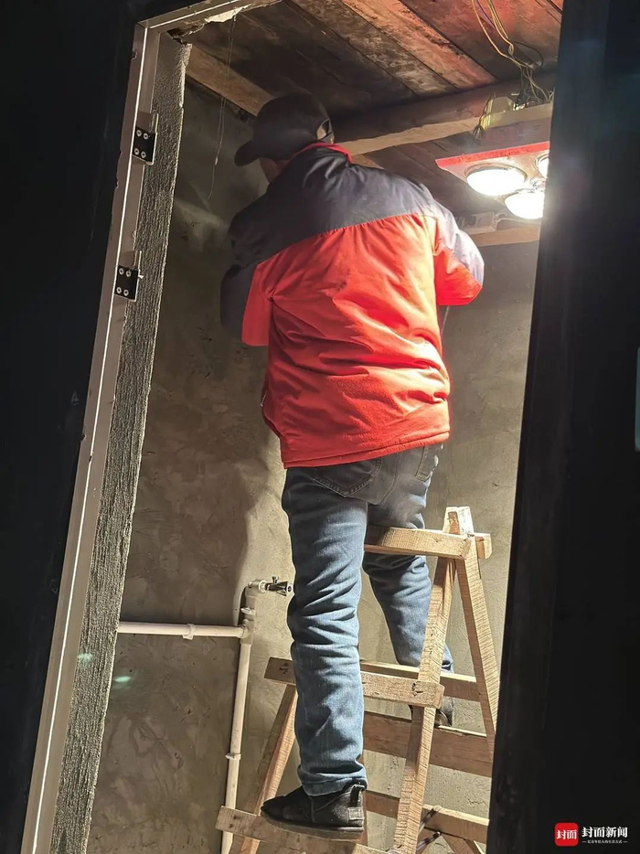 老宅内，工人师傅正在安装热水器