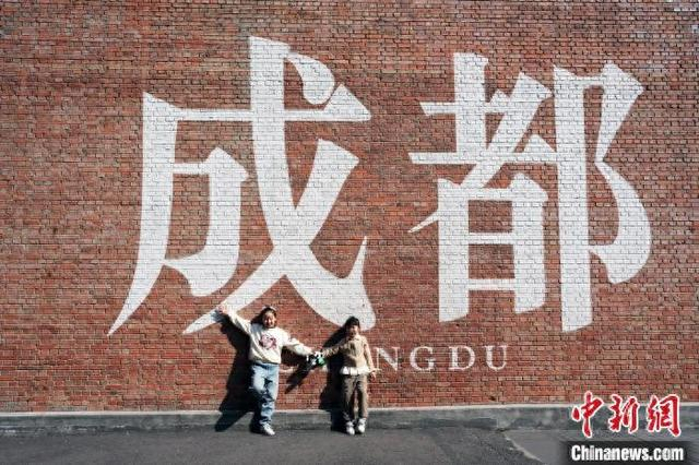 图为2月3日，小朋友在成都市东郊记忆园区举办的“艺术游园会”春节主题活动设置的“成都”打卡墙前拍照留念。 记者 安源 摄