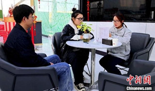 吴静越在查看补贴到账情况，领取商家给的保养优惠券。闫兆霞 摄