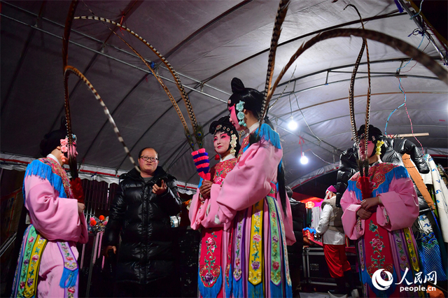 舞台旁，一名年长的演员正在为候场的年轻演员们讲解表演要领。人民网记者 时雨摄