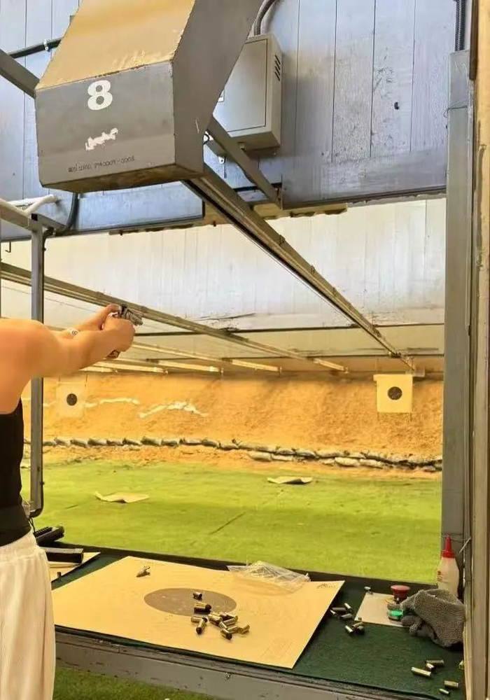 图：奥莉戴着耳罩，在教练员指导下射击