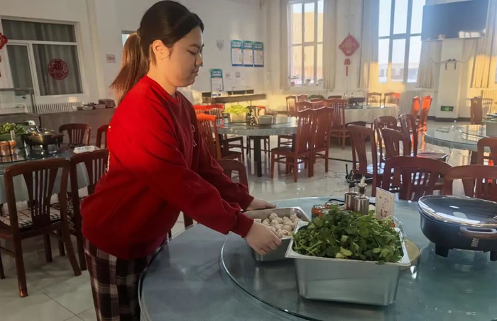 小嘉忆帮助食堂工作人员备菜。