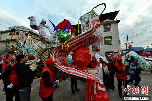 2月10日，村民抬着龙头准备接龙。中新社记者 张斌 摄