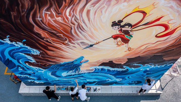 2022年4月29日，云南省玉溪市红塔区共美家园小区，“墙画师”给墙画《哪吒闹海》补色（无人机照片）。新华社记者胡超 摄