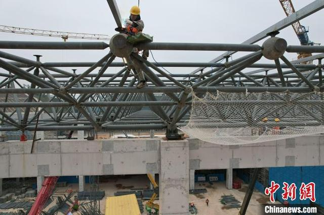 图为施工人员在站房上进行焊接作业。 记者 蒋雪林 摄