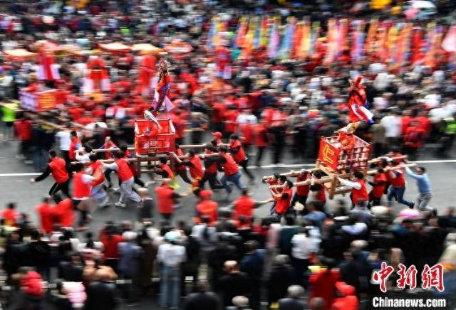 图为2月11日，走古事队伍在陆地竞逐狂奔。 中新网记者 张斌 摄