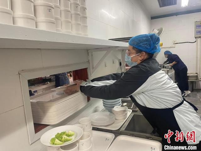 图为潘承颖在后厨备餐。张煜欢 摄