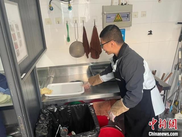 图为陈志昂在处理餐后垃圾。张煜欢 摄