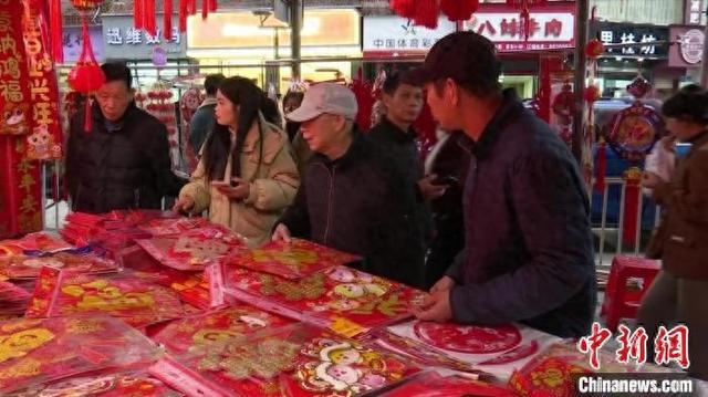 图为市民在街边年货摊购买年货。 潘传胜 摄