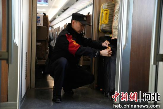 图为石家庄铁路公安处乘警支队乘警杜雪在为相似行李张贴支队制作的防止错拿的“提示贴”。 贾义涵 摄