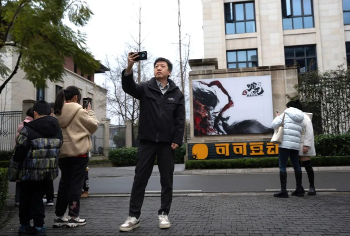 2月8日，影迷们在成都可可豆动画影视有限公司前打卡。新华社 图