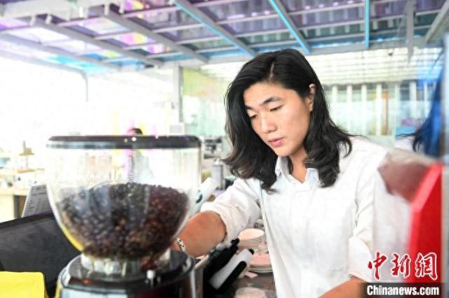 图为2024年11月3日，吴育名在香香花园内制作茉莉拿铁咖啡。中新社记者 蒋雪林 摄