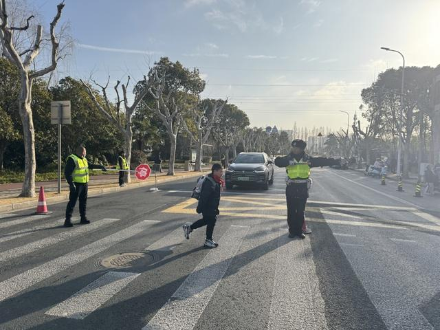 7点40分，进才实验小学西校门口前，交警指挥校门口车辆让行学生。澎湃新闻记者 徐亦嘉 图