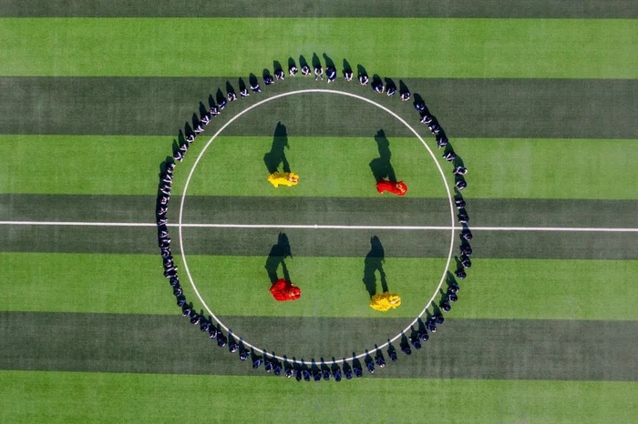 2月14日，山东省淄博科技学校龙狮社团的学生在操场上进行舞狮演练（无人机照片）。新华社发（张维堂摄）