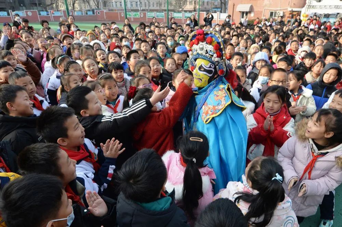 2月14日，学生们在山东青岛四方小学“传统文化润童心”主题活动中与川剧变脸演员互动。新华社发（王海滨摄）