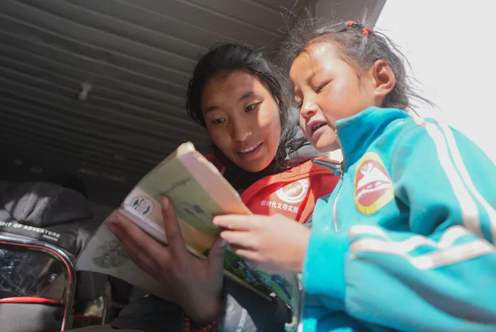 1月25日，在定日县曲洛乡热木青村安置点，大学生志愿者在安置点在给孩子们辅导功课。新华社记者 晋美多吉 摄