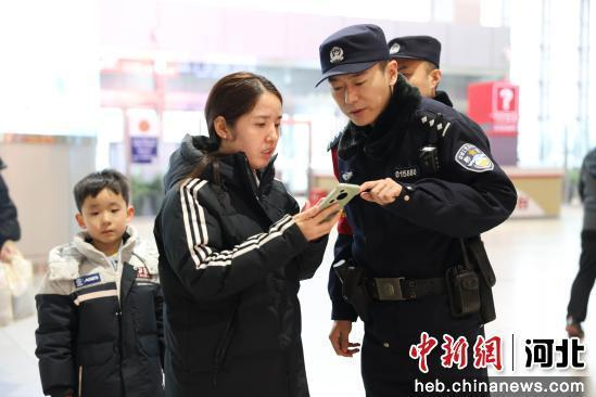 图为邯郸东站派出所民警在候车室解答旅客疑问。 陈增凯 摄