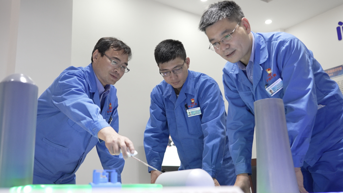 郭佳宁和同事们在创新工作室开展学习交流。首钢京唐钢铁联合有限责任公司供图