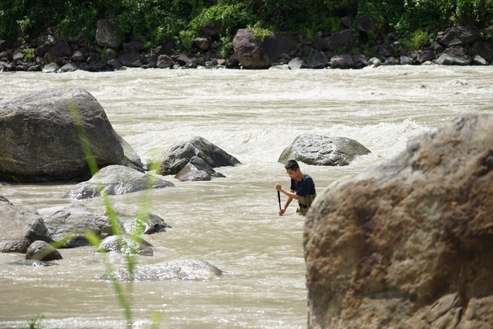 2023年7月，郑徐弘毅在西藏墨脱的雅鲁藏布江中捞蜉蝣。  受访者供图