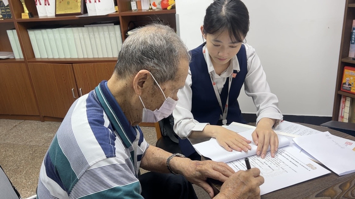 中华遗嘱库工作人员协助市民填写资料。  受访者供图
