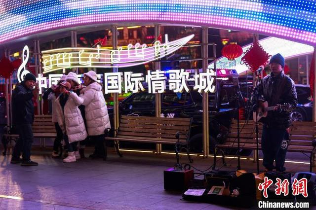 2024年12月24日，四川康定，游客在“中国康定国际情歌城”标志前合影。中新社记者 薛蒂 摄