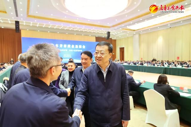 图为：自治区党委副书记、市委书记张柱同企业家代表握手。