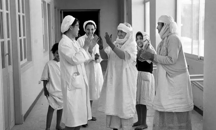 1966年5月，在阿尔及利亚西部的玛斯卡拉，两位经过中国医生医治后重见光明的患者和中国女医生一起拍手欢呼。新华社