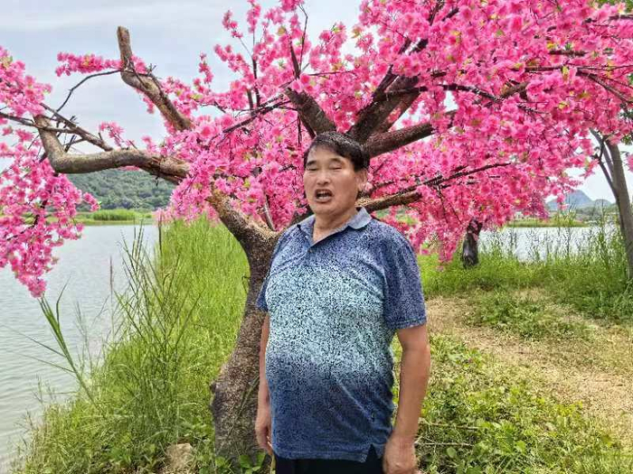 朱之文在树下放声歌唱。受访者供图