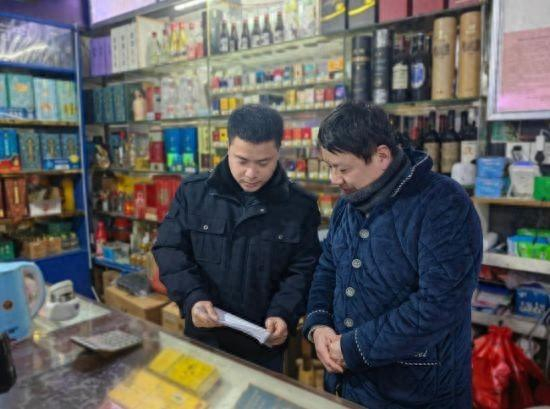 图为进贤烟草工作人员向零售户宣传“12313”举报投诉热线。杨振武摄