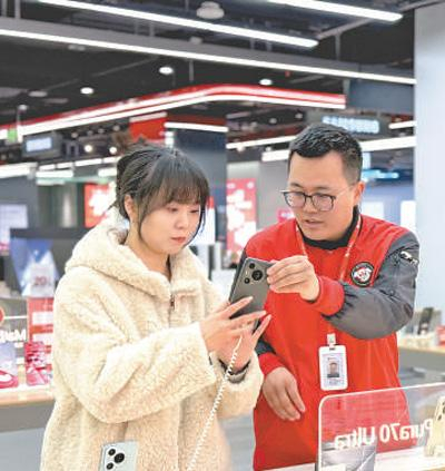 消费者（左）在湖北武汉一家商场里挑选手机。本报记者 吴 君摄