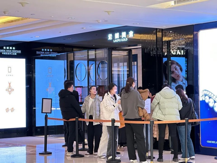 2月21日晚七点半，老铺黄金国贸商城店门口挤满了排队的顾客。图/于盛梅 摄