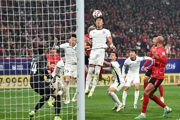 2月22日，武汉三镇队球员刘奕鸣（上）在比赛中争顶头球。新华社记者 胥冰洁 摄