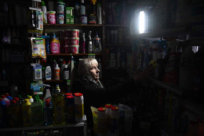 当地时间2024年11月28日，乌克兰利沃夫，一名当地居民在商店内待着，俄罗斯对乌克兰能源基础设施的攻击导致局部停电。