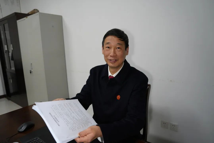 邹蜀奇法官向记者展示一份64页共3万余字的判决书。（覃瑶/摄）
