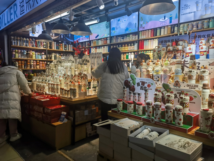 图为消费者在选购保温杯。